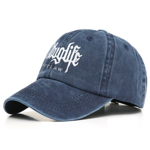 Close-up of embroidered Thuglife Outlaw text on washed blue cotton baseball cap