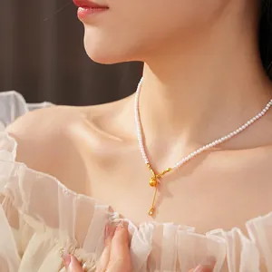 Elegant pearl necklace with gold gourd pendant and tassels on model collarbone