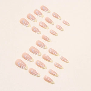 Almond-shaped press-on nails with yellow French tips and delicate floral leaf patterns