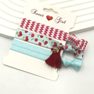 Detail of sweet floral elastic hair bands with cherry pendants on display card