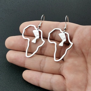 Gros plan détaillé des boucles d'oreilles carte Afrique argentées avec profil Néfertiti