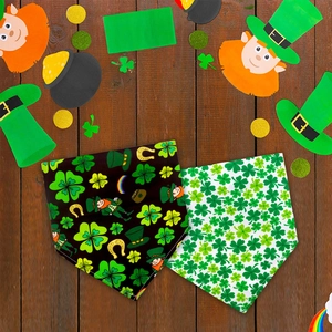 Flat lay of St. Patrick's Day pet bandanas with clover patterns on a wooden floor