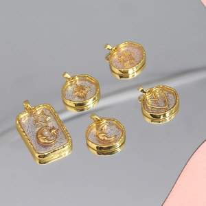 Detail of five gold resin pendants featuring stars, moon and glitter on mirror base