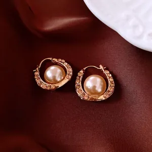 French style gold U-shaped earrings with pearls and amber rhinestones on velvet