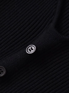 Close-up of the black ribbed knit fabric and round button details on the midi dress