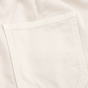 Dettaglio macro della trama del tessuto in twill di cotone bianco crema e cuciture