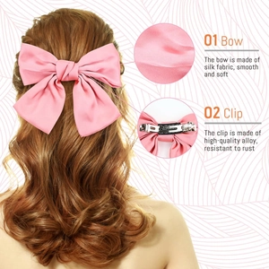 Detail showing the pink silk fabric bow texture and its high-quality alloy metal clip