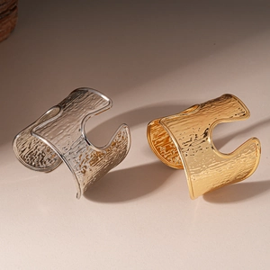 Modern metallic cuff bracelets in gold and silver with hammered texture and open design