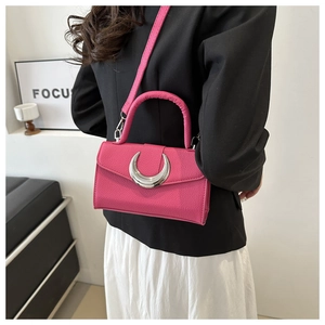 Détail du sac à main en cuir rose avec boucle en croissant d'argent et bandoulière fine