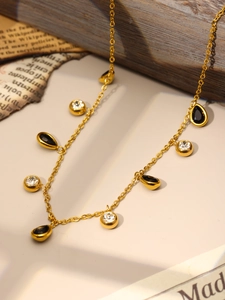 Detail of 18k gold plated necklace featuring black teardrop and clear round crystals