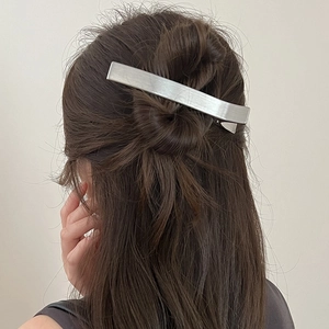 Barrette en métal argenté brossé minimaliste portée par un modèle pour la coiffure