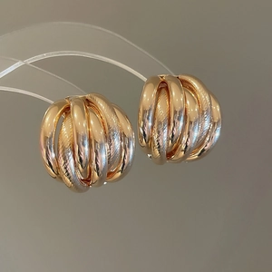 Macro shot of gold-plated multi-layer hoop earrings with polished and textured finishes