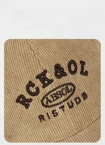 Close-up of khaki corduroy baseball cap showing textured fabric and 3D letter embroidery