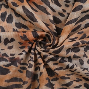 Gros plan sur le tissu en maille respirant avec imprimé léopard orange et marron