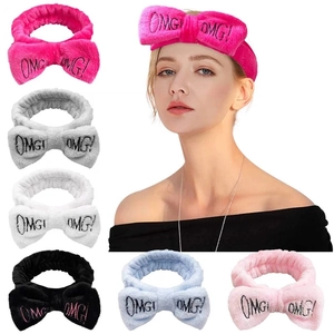 Multi-color selection of plush bow headbands with embroidered OMG lettering for skincare