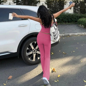 Dettaglio del top all'americana rosa acceso e dei pantaloni yoga a zampa in esterni