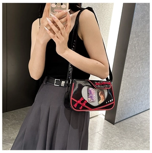 Detail of black ita bag featuring heart window with anime cards and red bow accent