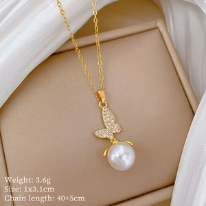 Detail of gold butterfly necklace with pearl and rhinestones in an elegant jewelry box