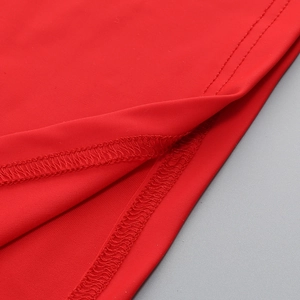 Close-up of red knit dress showing high-quality double-needle stitching and fabric texture