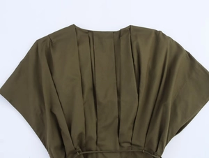 Vue détaillée d'une robe midi vert armée avec plis verticaux et lien à la taille
