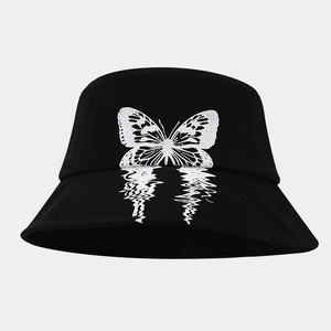 Close-up of black bucket hat featuring a white butterfly print with creative fluid wave ripple