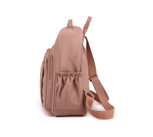 Detail of pink nylon backpack featuring elastic side pockets and smooth metal zippers