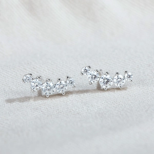 Detailed shot of curved sterling silver stud earrings with five round moissanite stones