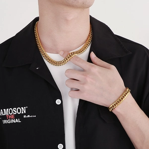 Polished gold Cuban link chain necklace and bracelet set shown on male model with black shirt