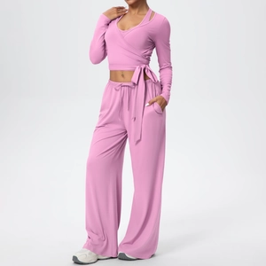 Détail de l'ensemble de yoga rose avec haut cache-cœur à nouer et pantalon évasé