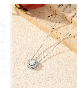 Exquis collier en argent 925 avec pendentif en moissanite à côté d'une rose rouge