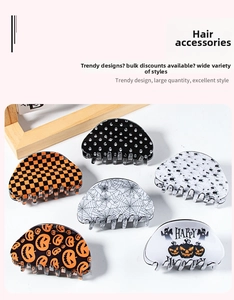 Detail of Halloween hair claws featuring pumpkin and spider motifs on white background