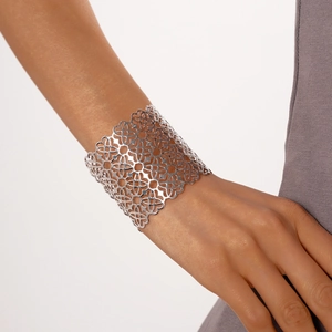 Dettaglio del bracciale rigido argento traforato con motivi floreali geometrici