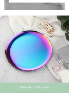 Close-up of a rainbow iridescent round stainless steel jewelry tray on white fabric