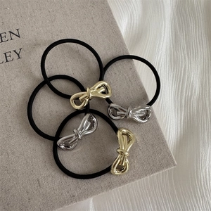Set of four black high-elasticity hair ties with gold and silver metal bow accents