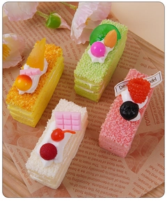 Détail de quatre faux gâteaux mousse assortis avec garnitures de fruits réalistes