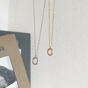 Detail of 925 sterling silver oval donut pendants in gold and silver textured finish