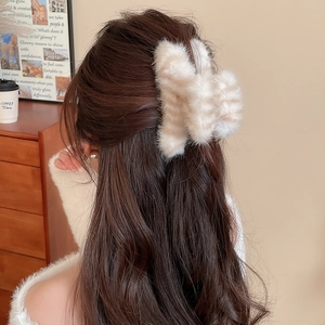 Détail d'une pince à cheveux en peluche rayée dans une coiffure élégante et moderne