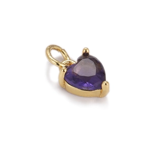Macro shot of gold-plated heart pendant with purple zircon gemstone for jewelry making