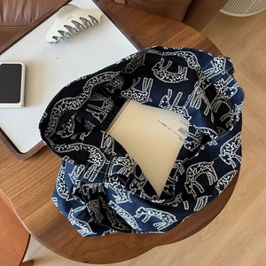 Detailed macro view of navy blue canvas tote bag with white giraffe patterns and books