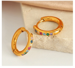 Vue détaillée de créoles dorées ornées de zircons multicolores effet arc-en-ciel