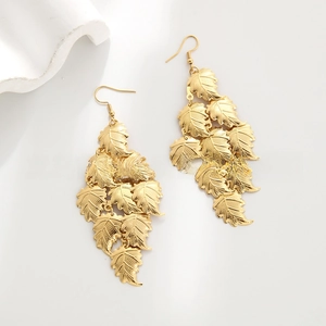 Macro detail of multi-layered gold leaf drop earrings with intricate leaf vein texture