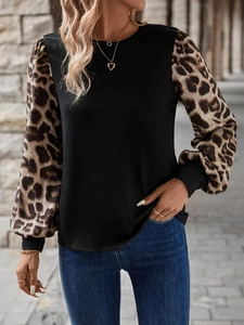 Detail of fashion long sleeve T-shirt with leopard print sleeves and black knit bodice