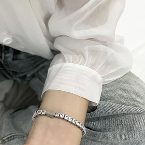 Detail shot of a silver tennis bracelet with sparkling 3A zircons worn on a female wrist