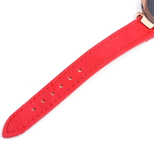 Close-up of red leather watch strap with lychee texture and rose gold connector