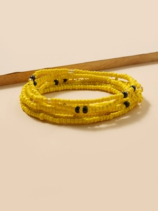 Detail of yellow and black handmade beaded body chain with a bohemian layered texture