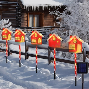 Solar Christmas path lights with red house design and striped candy cane stakes in snow