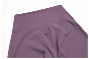 Détail de la taille haute en V sur un pantalon de yoga violet avec coutures plates
