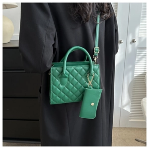 Detail of green quilted crossbody bag with gold chain strap and matching coin purse