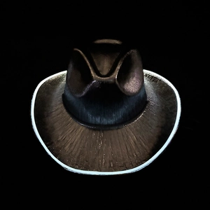 Detail of LED glowing cowboy hat with blue fiber optic light trim on black base
