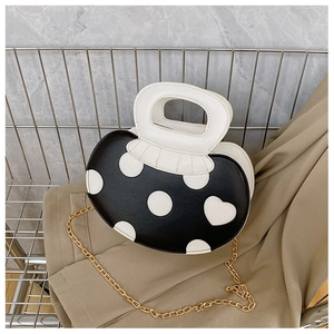 Detail of creative apple-shaped handbag featuring polka dot patterns and U-shaped handle